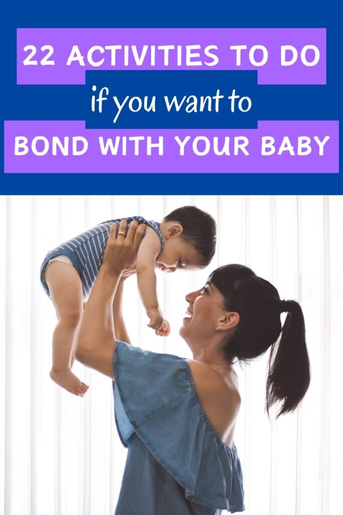 mom holding young baby up in front of a window looking at baby smiling and laughing