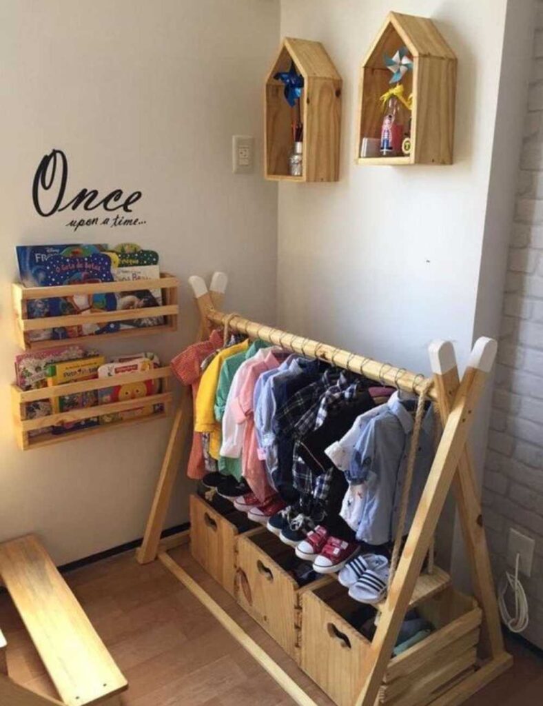 picture of a nursery showing a teepee inspired clothing rod, and books in two shelves on the wall.