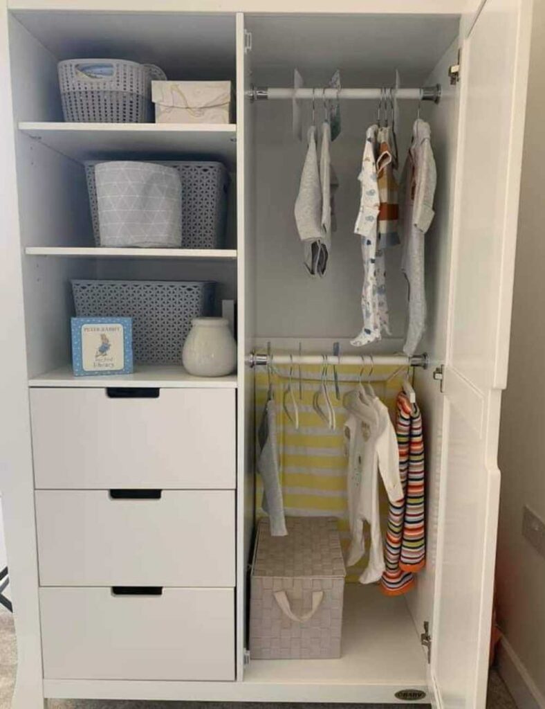 freestanding wardrobe with doors opened showing two clothing rods on one side and drawers and shelves on the other side.