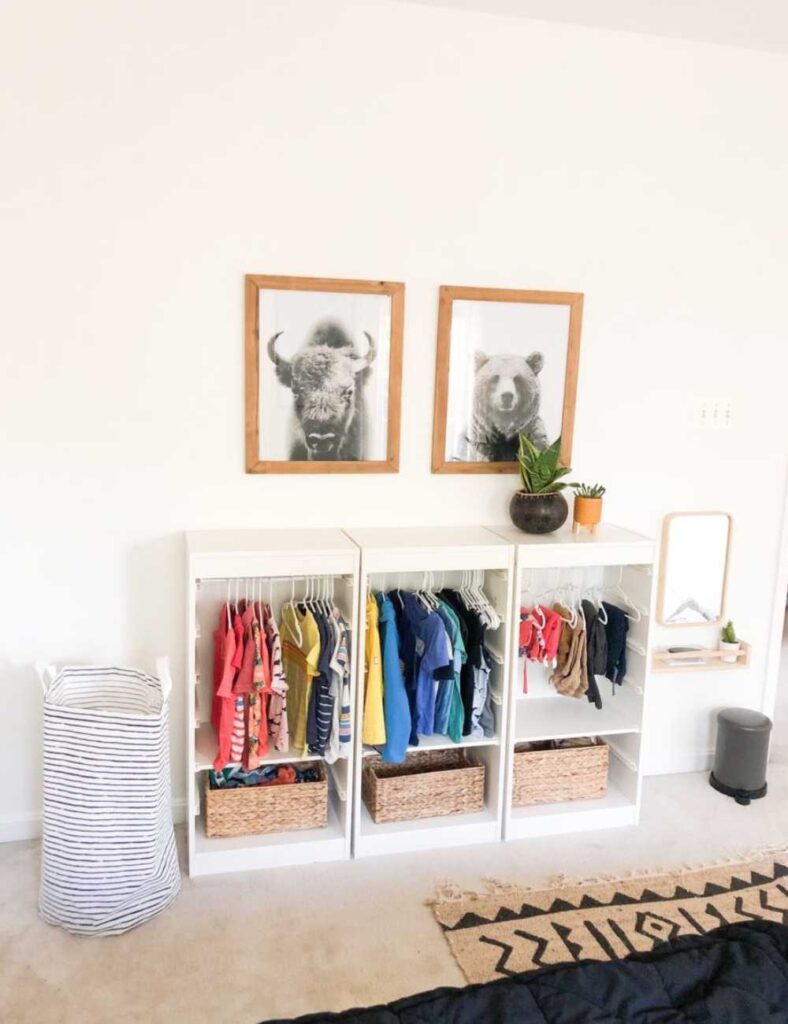picture of a toddlers room with three open ikea type units for clothing storage.