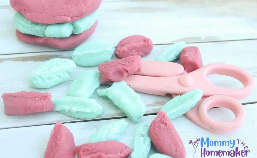 picture of pink and blue playdough cut up using playdough scissors